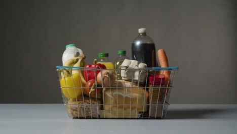 Studio-Shot-Of-Basic-Food-Items-In-Supermarket-Wire-Shopping-Basket-4