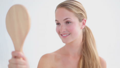 smiling blonde woman holding a mirror