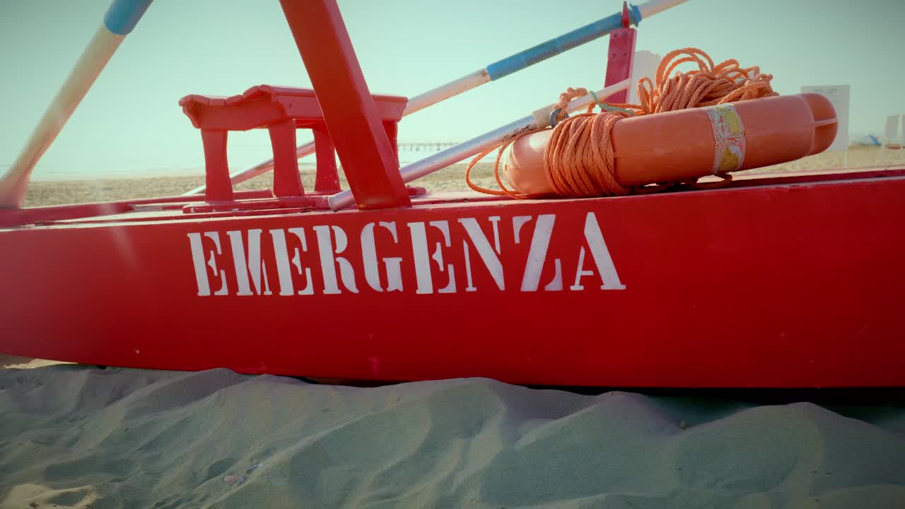 Detaljer af rødt livredderudstyr på en redningsbåd på Rimini strand i morgenlys, adriaterhavskysten