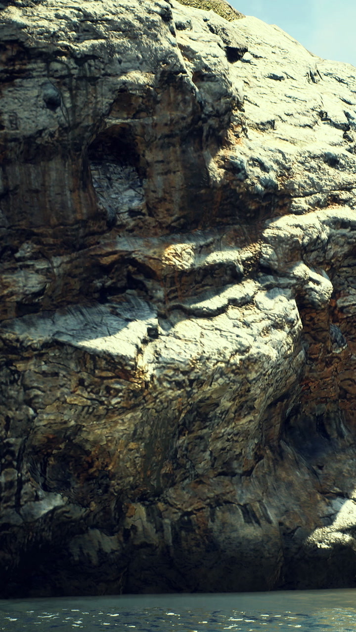 Majestic rock formations rise above calm waters on a sunny day