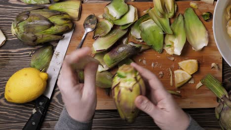 Woman-cleaning-artichokes.-Cooking-process-at-the-kitchen.-Closeup