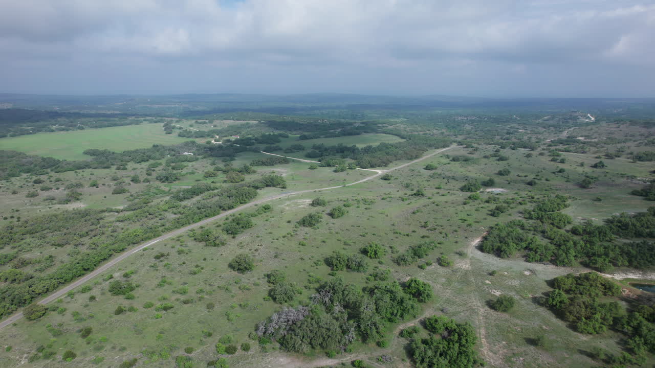 vista aérea de una granja rural en el país de las colinas de texas en un día nublado