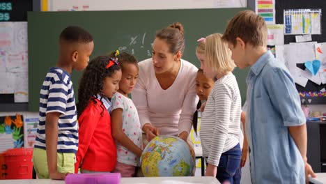 Vorderansicht-Einer-Kaukasischen-Lehrerin,-Die-Im-Klassenzimmer-4K-über-Den-Globus-Erklärt