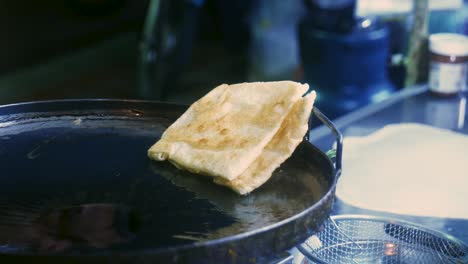 4k cinematic cooking footage of a thai chef preparing a traditionnal thai dessert called roti in a street market in thailand