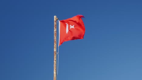 turkey flag flattering on wind against blue sky. red turkish flag waving on flagpole. national flag and sign of turkey