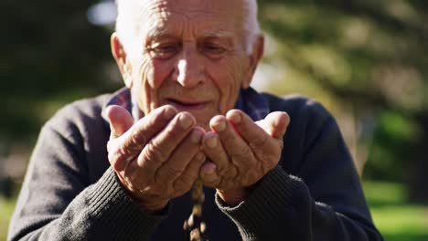 an elderly man cherishes a handful of tiny treasures in a serene outdoor setting, reflecting joy and nostalgia while connecting with nature's beauty.