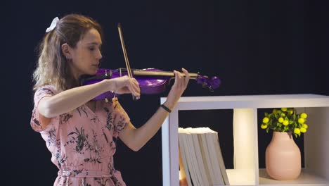 happy musician woman enjoys playing the violin.