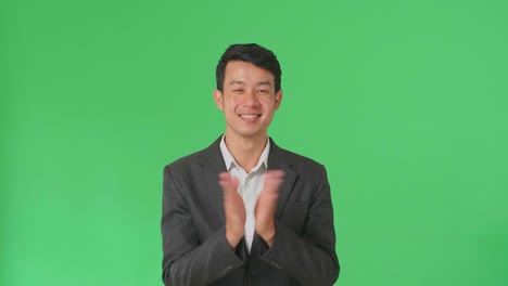 young asian business man clapping her hands in the green screen studio