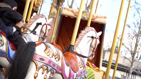 young child rides colorful old-fashion carousel horse, tivoli gardens, copenhagen, denmark, close up slow motion pan