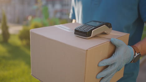 postman or delivery man carry small box deliver to customer at home contactless nfc terminal payment.