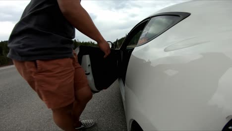 man getting into his white car