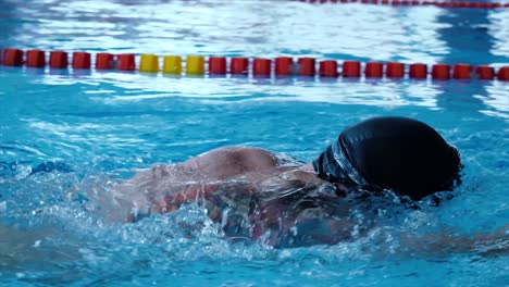 persona nadando estilo libre en una piscina cubierta