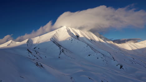 pico de montaña nevado al amanecer o al atardecer