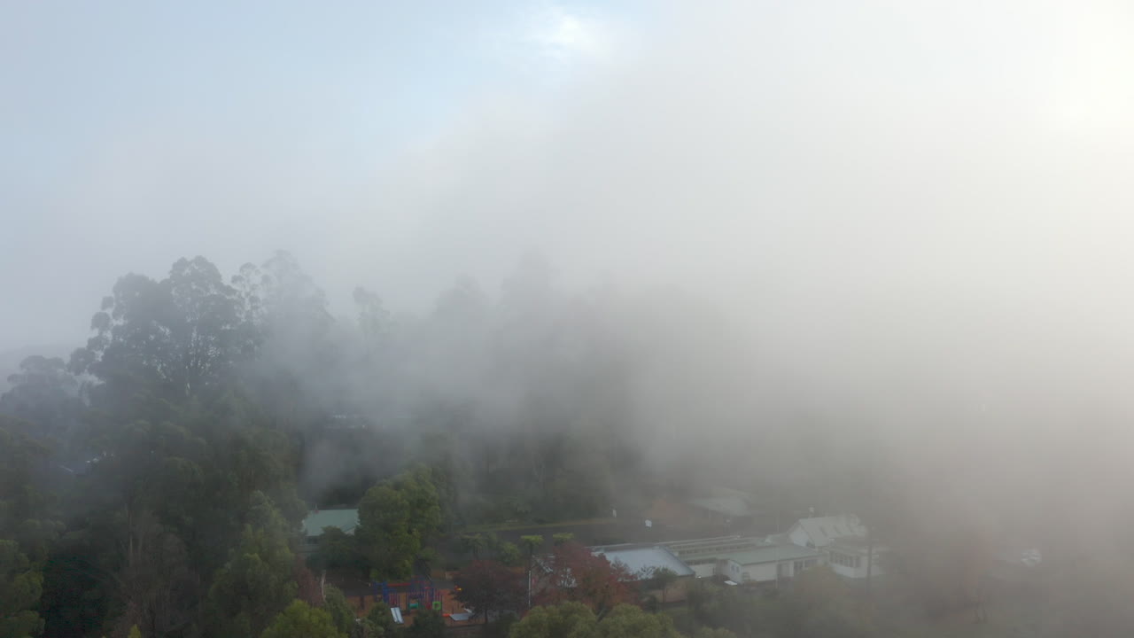 짙은 안개 롤링이 있는 차가운 마을 위에 부드러운 악센트