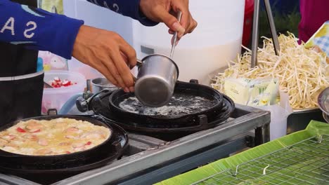 street food vendor cooking thai omelet with seafood