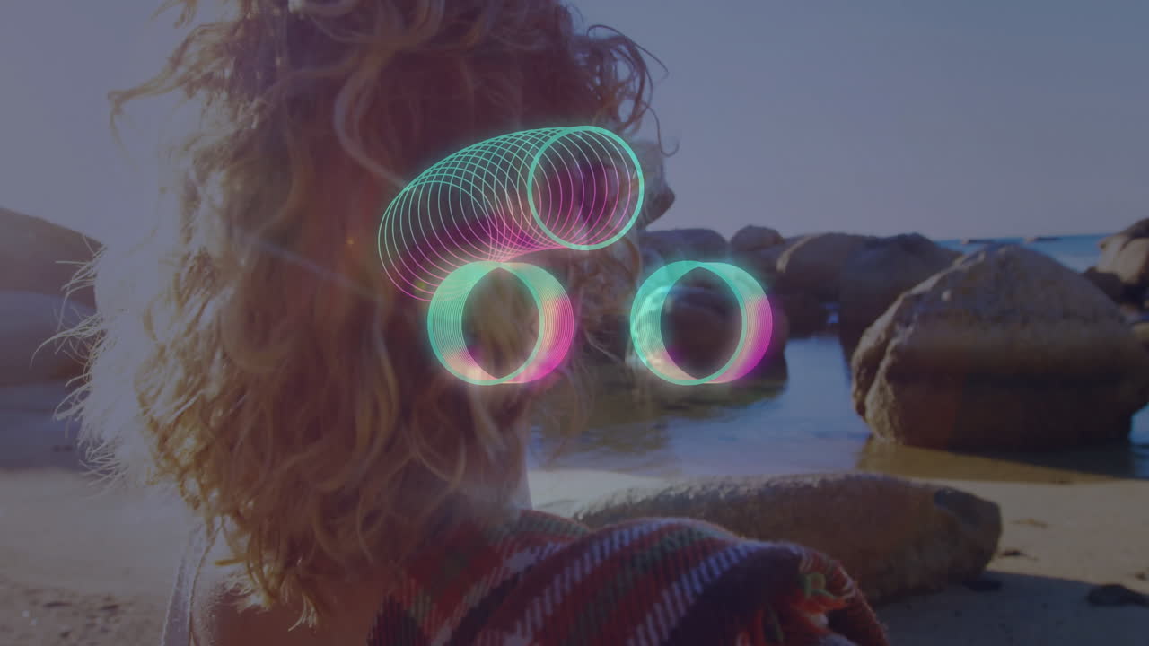 Curly-haired person at beach with glowing circles animation over rocky shore