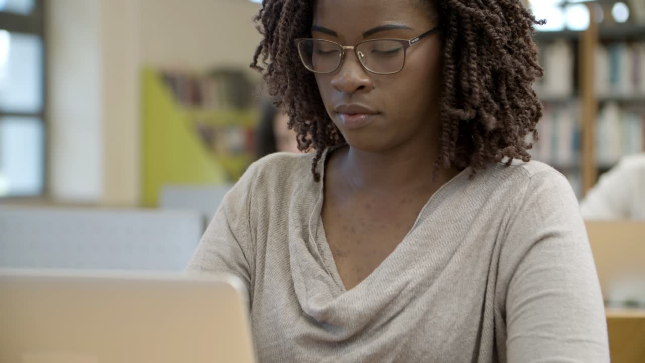 Closeup shot of serious African American woman using laptop