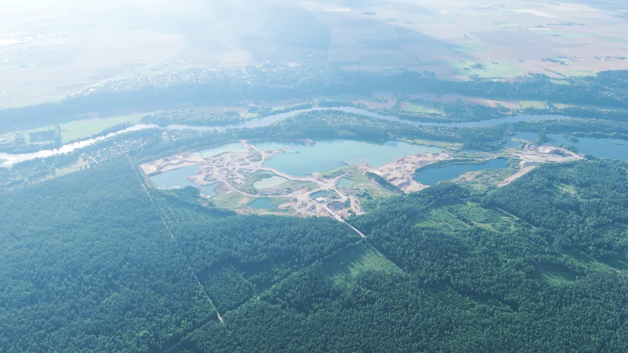 Quarry with water ponds surrounded by forest in Lithuania, aerial view
