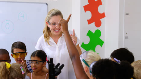 niños de la escuela levantando la mano en el laboratorio