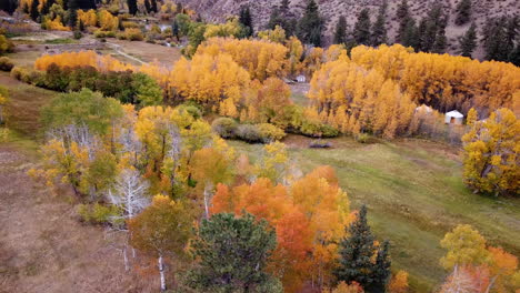 aerial view of colorful landscape in american countryside, yurt tents and forest in vivid foliage, drone shot