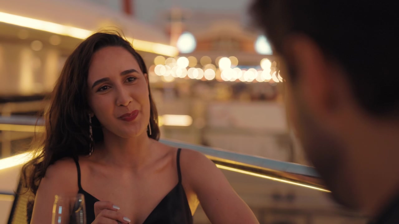 Giovane donna che mangia un dessert e sorride durante una cena romantica
