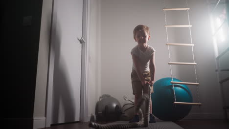 Motivated-toddler-tries-workout-with-battle-rope-in-hands