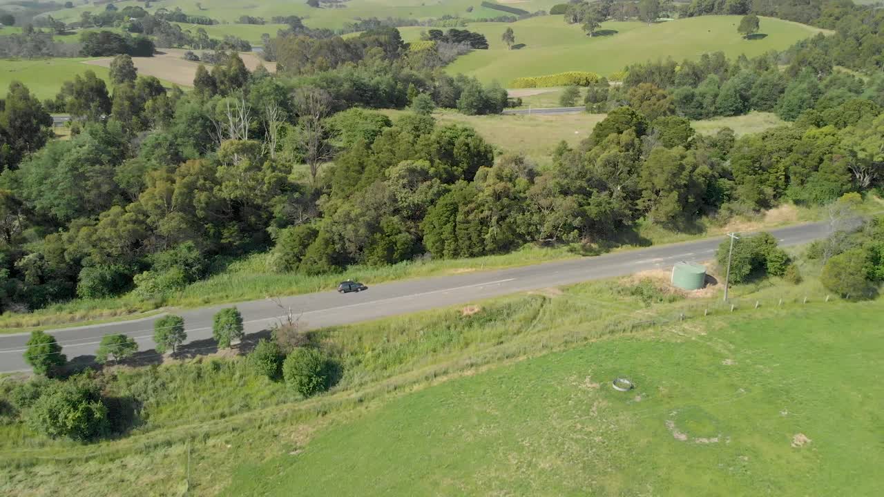 오스트레일리아 strzelecki 범위의 푸른 언덕에 있는 시골길에 주차된 자동차
