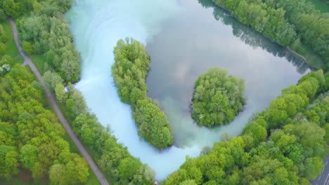 lush forest, clouds reflected on blue water lake, bochum werne, germany