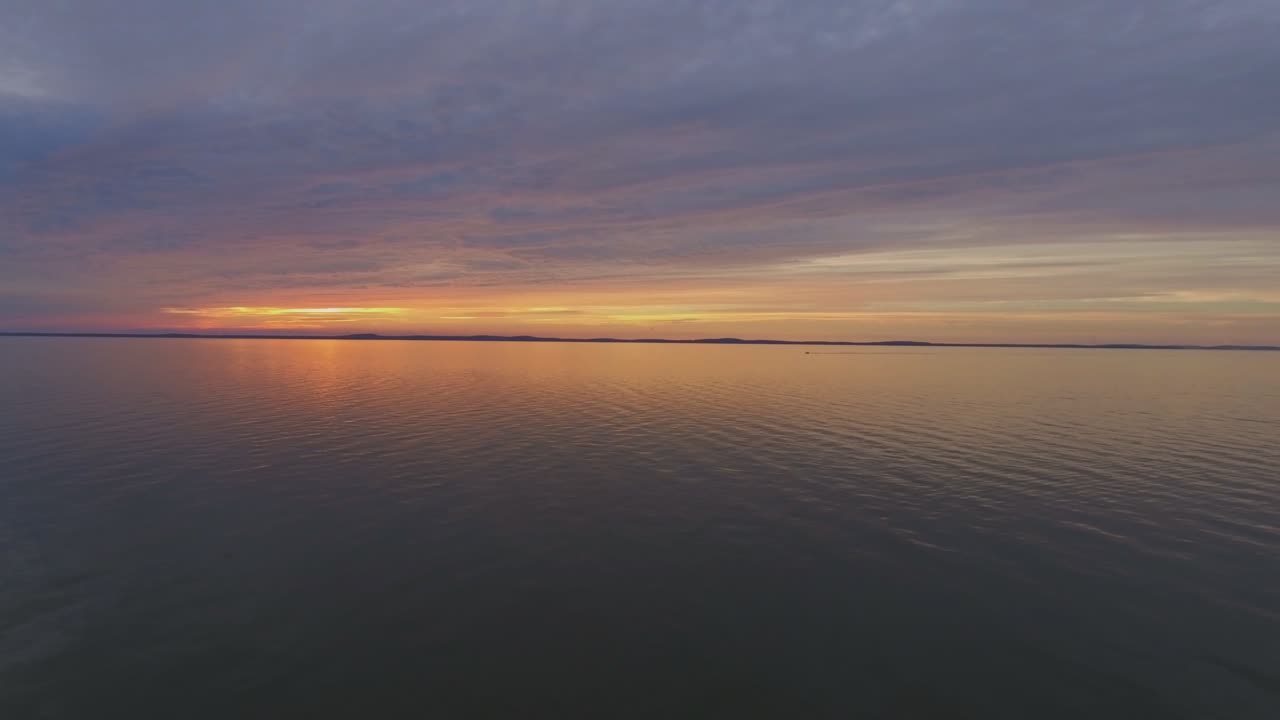 одна яхта далеко в куршской лагуне на закате солнца