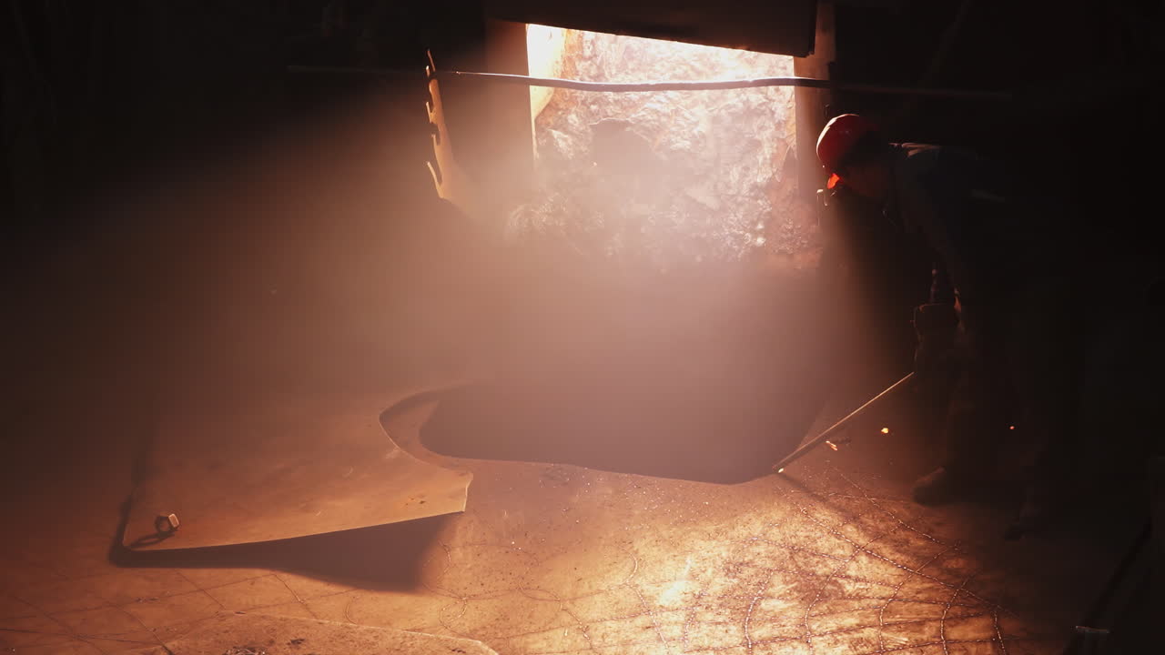 溶けた金属の残骸を除去する産業労働者