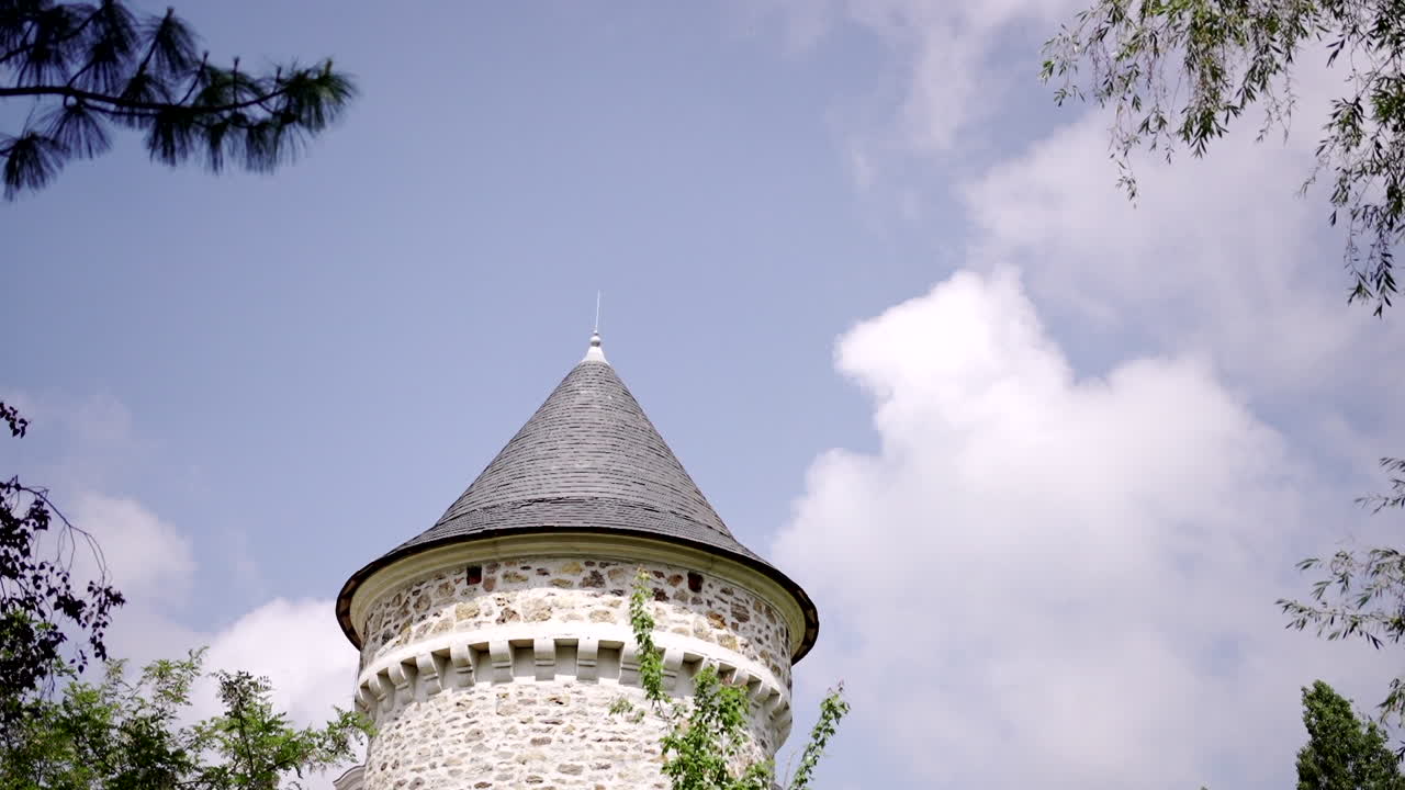 밝은 파란 하늘과 초록색을 배경으로 피침 모양의 지붕을 가진 돌 성탑