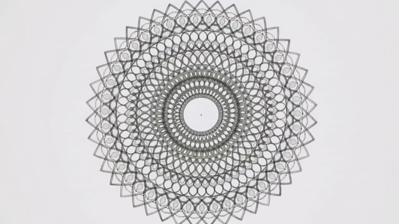 Video verticale: Mandala centrale che si sposta rispondendo al cambio di inquadratura, creando un effetto moiré su uno studio chiaro.
