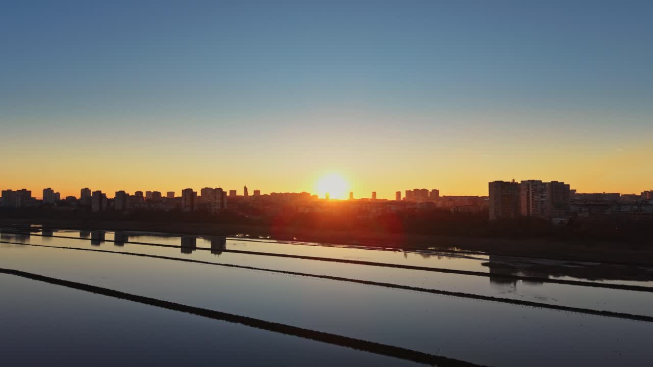 Sunrise over salt fields near urban area