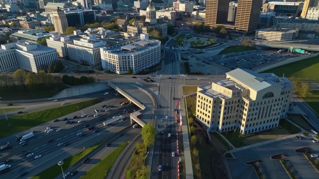 Nathan Deal Judicial Center in front of Atlanta Skyline during sunset. Aerial tilt up wide shot. Cars on highway interstate in slow motion. Georgia, USA.