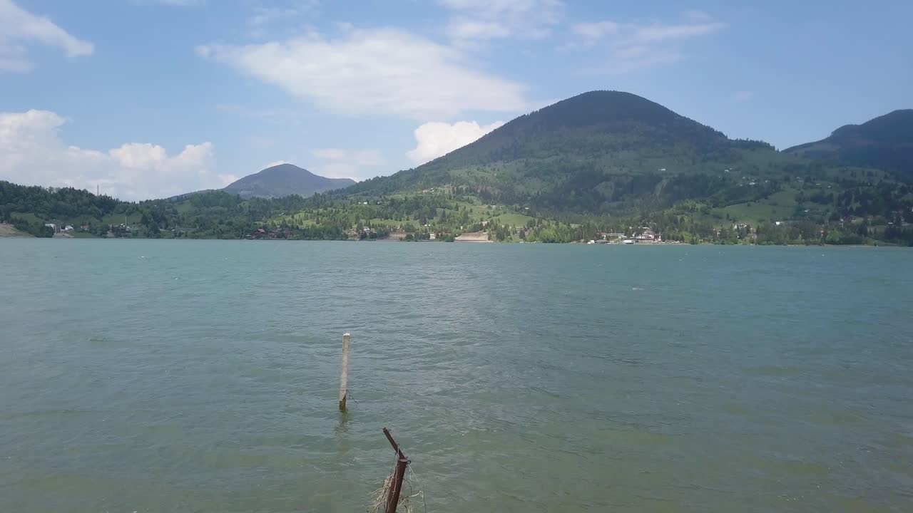 호수의 공중 설정 샷 - 산을 배경으로 철조망을 통해 저수지