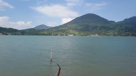 Toma-Aérea-Del-Lago---Embalse-A-Través-De-Alambre-De-Púas-Con-Montaña-En-Segundo-Plano