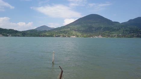 aerial establishing shot of lake - reservoir through barbe wire with mountain in background