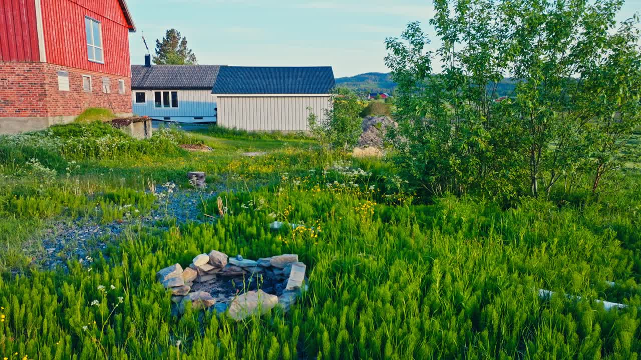 Grass Growing In The Backyard Near The Barn And Houses. Aerial Dolly Shot