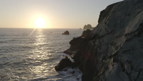 Drone-flying-towards-the-sunsetting-on-the-pacific-ocean