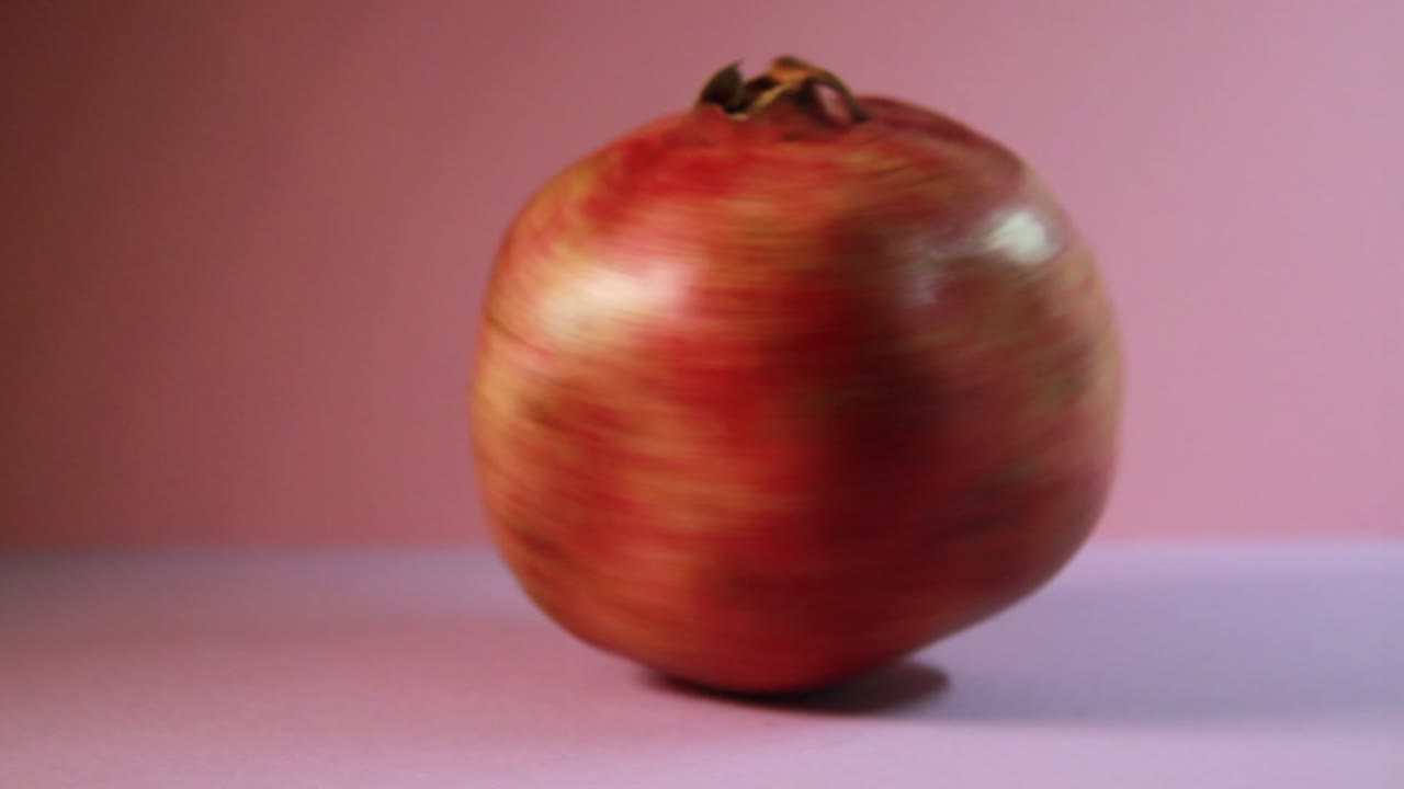 Granatæble i hurtig rotation. Nærbillede fra studie.