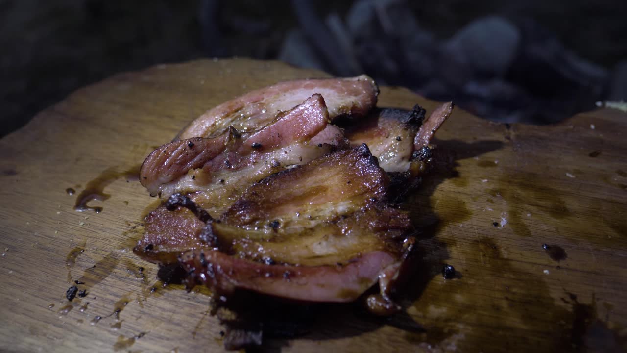 Grilled ham on a low heat, presented on a wood chopper. The ham is well browned