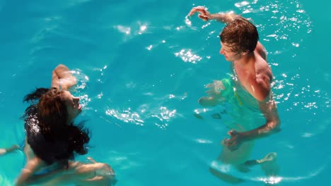 Pareja-Feliz-Divirtiéndose-En-La-Piscina