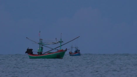los barcos de pesca en tailandia esperan en medio del océano a que oscurezca para poder encender sus luces verdes y comenzar a pescar y pescar camarones