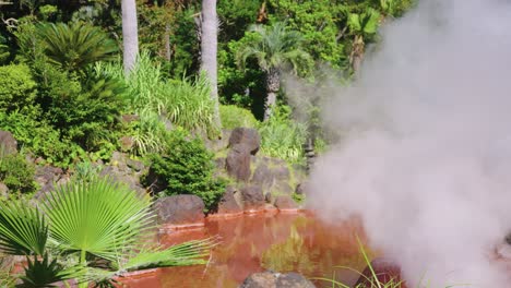 steam boils out of iron oxide pools at umi jigoku in beppu, oita japan
