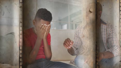 old film overlay effect against african american father consoling his stressed son