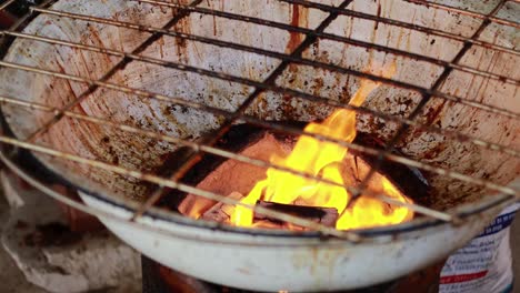 flames flicker on a grill at market