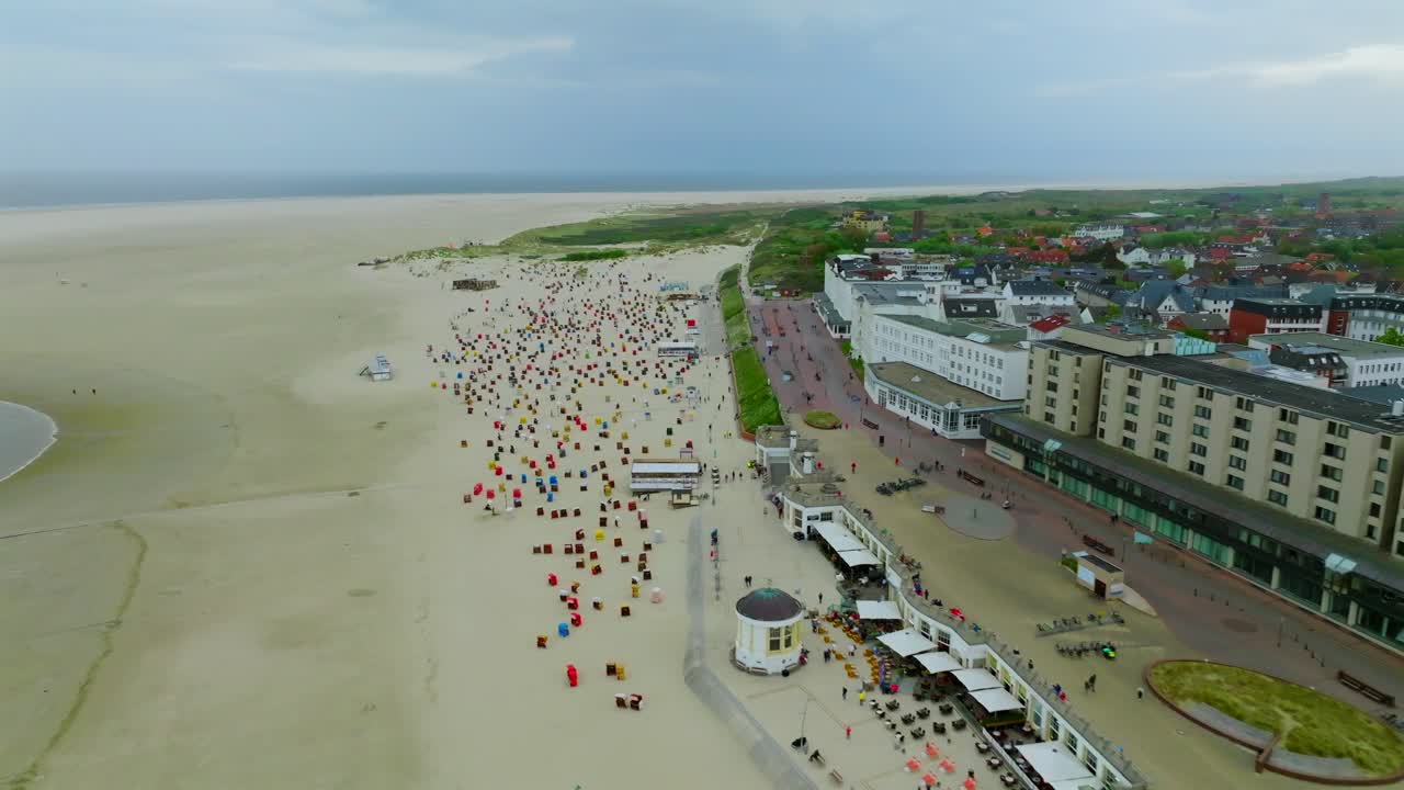 Dolly in flyover Borkum beach promenade highling historical spa hotels and colorful strandkorb beach chairs