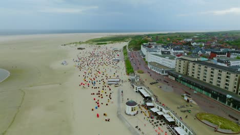dolly in flyover borkum beach promenade highling historical spa hotels and colorful strandkorb beach chairs
