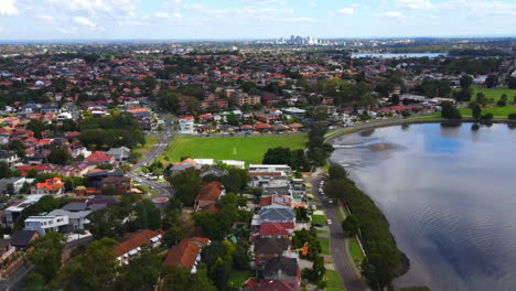 Drone-pan-180-of-suburbs-around-water-inlet-with-yachts-and-boats