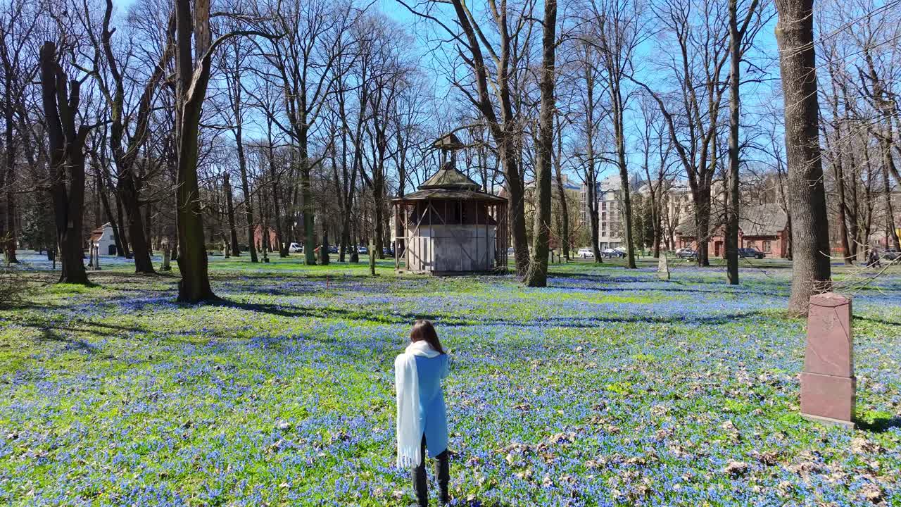 Aerial reveals young woman strolling among graves in Riga’s blooming cemetery